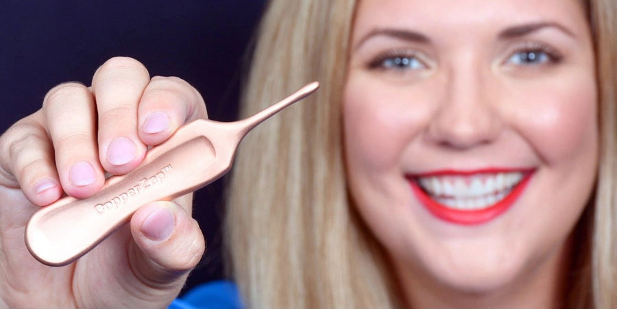 Person holding a copper tool with a smile.